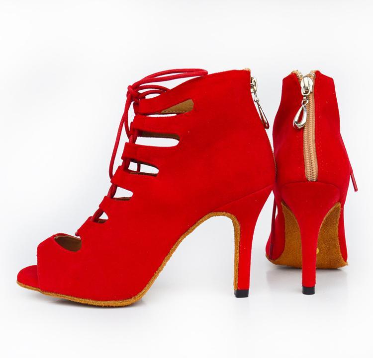 Red high-heeled shoes with cut-out design on a white background