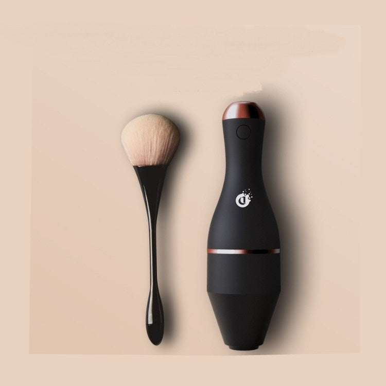 Black makeup brush and holder on a beige background