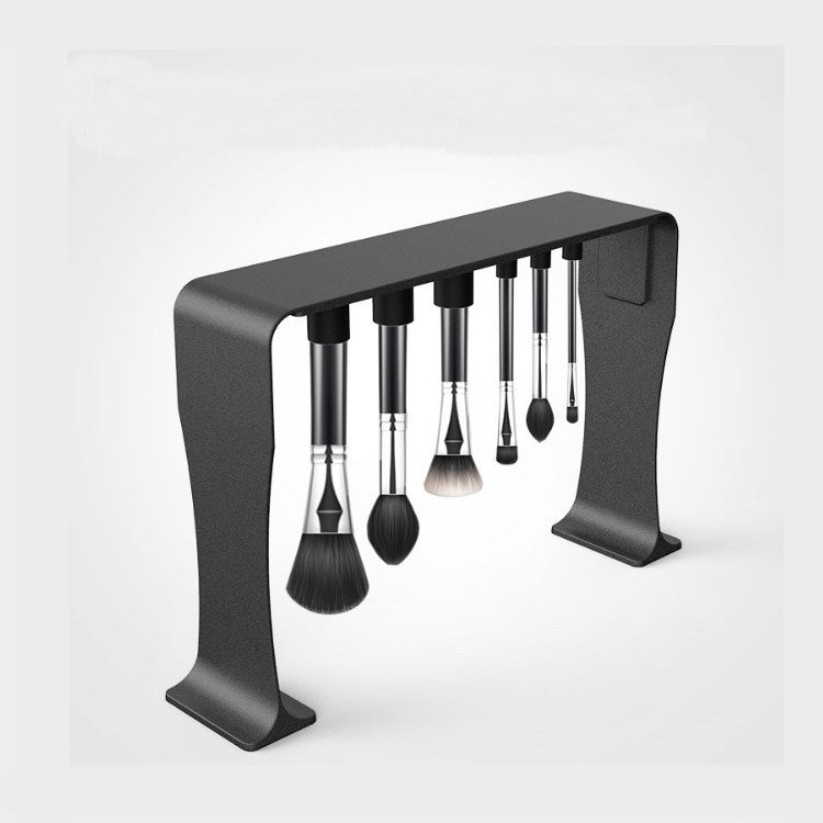 Set of makeup brushes on a black stand against a white background