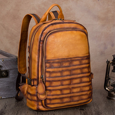 Brown leather backpack on a wooden surface with a rustic background