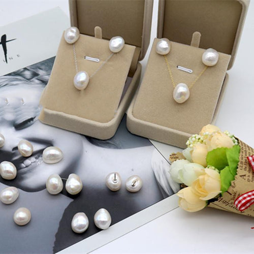 Pearl jewelry set on display with a decorative flower arrangement on a magazine background