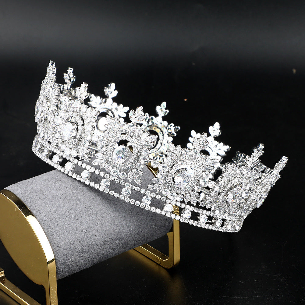 Silver tiara on a gray cushion with a black background