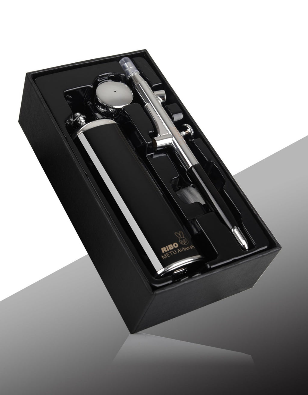 Black and silver shaving set in a box on a reflective surface