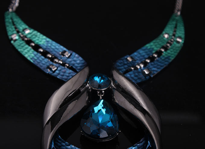 Necklace with blue pendant and greenish-blue strap on a black background