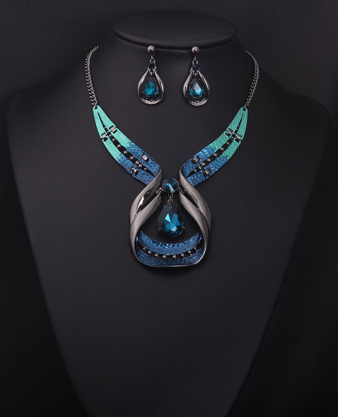 Jewelry set with necklace and earrings featuring blue gemstones on a black background