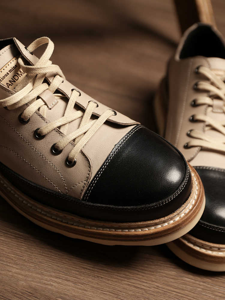 Pair of black and beige sneakers on a wooden surface