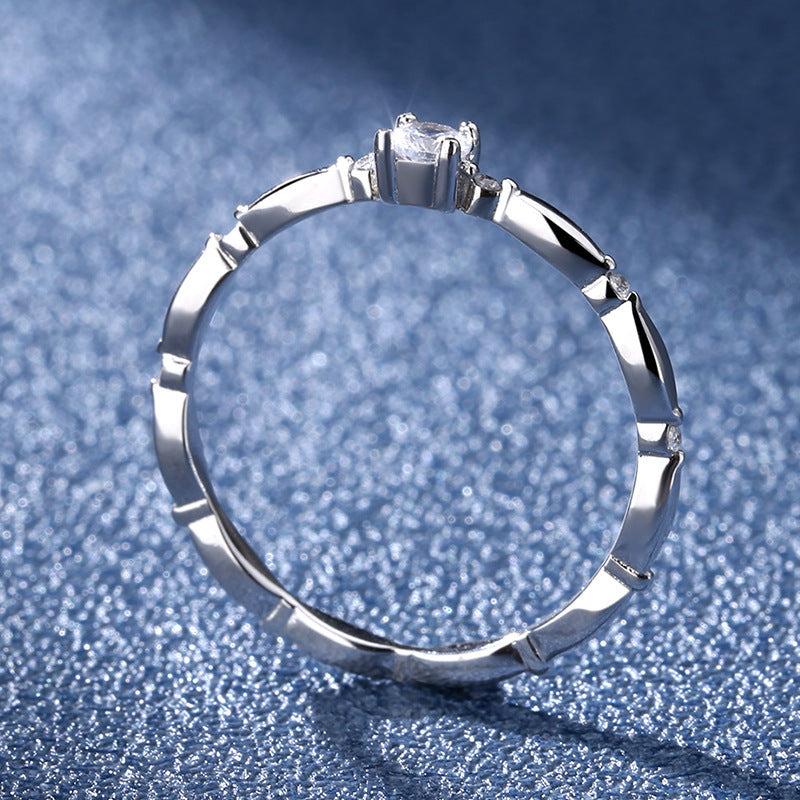 Silver ring with a diamond on a blue textured background