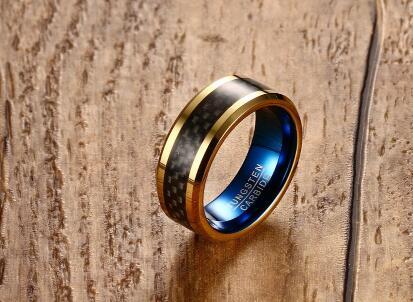 Gold and black ring with blue light on a wooden surface