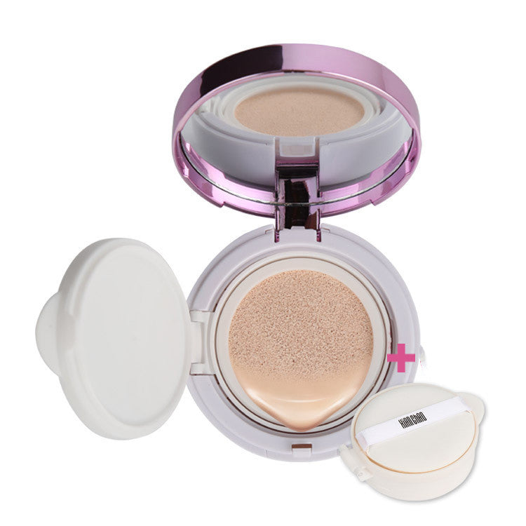 Makeup compact with pink lid and white base, containing a beige powder, on a white background.