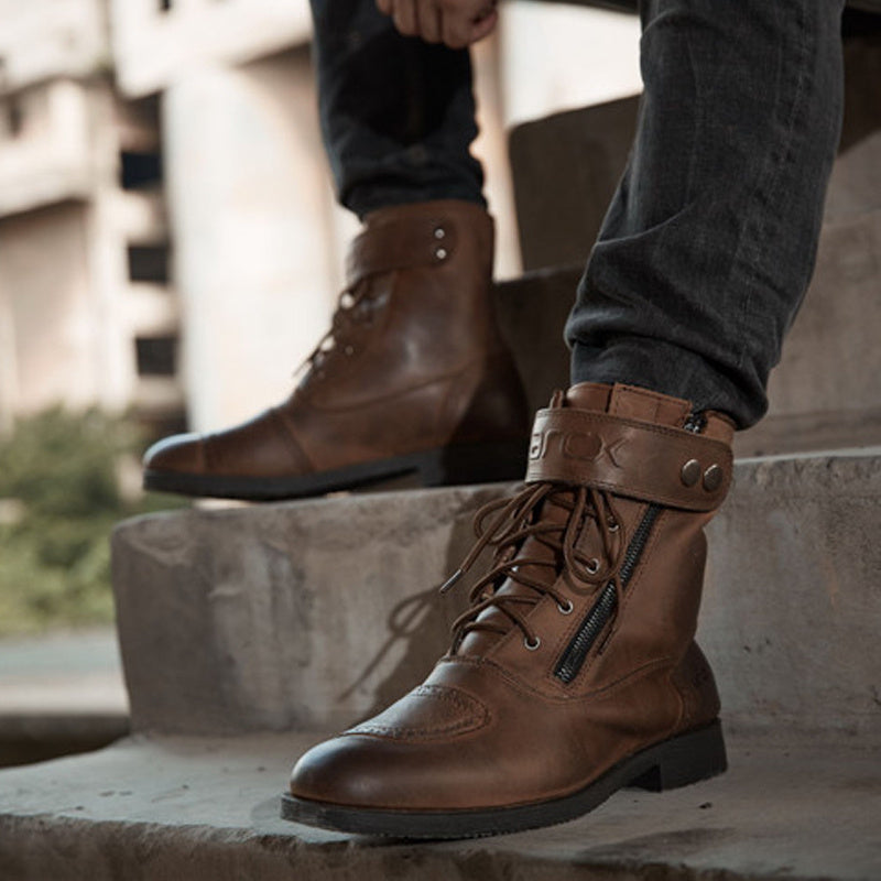 Brown leather boots worn by a person on concrete steps.