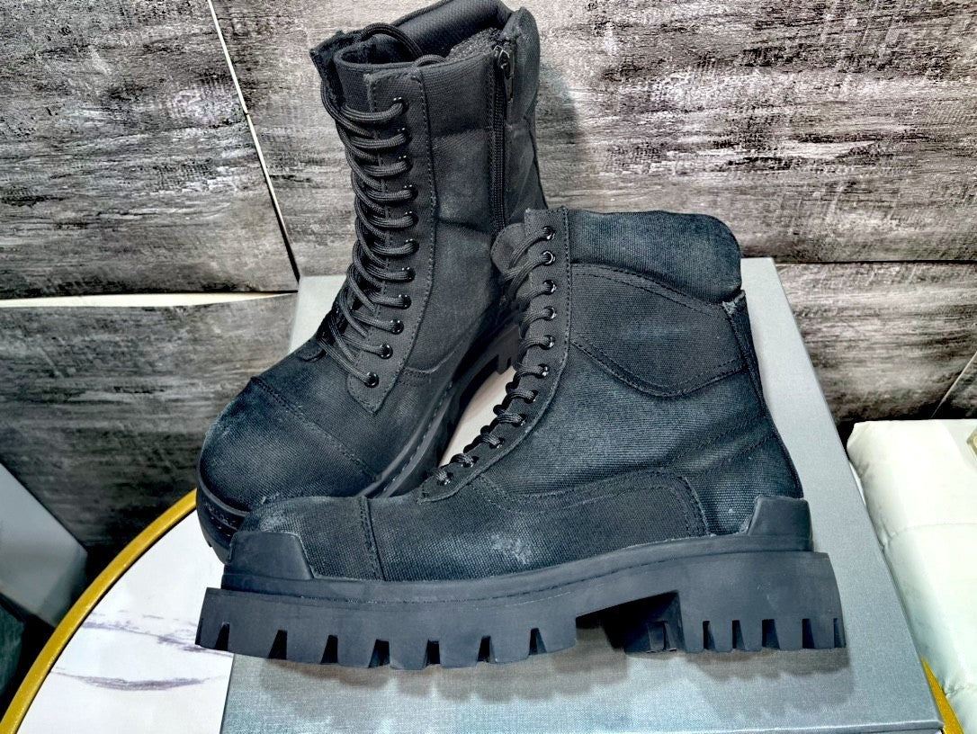 Black military-style boots on a wooden surface