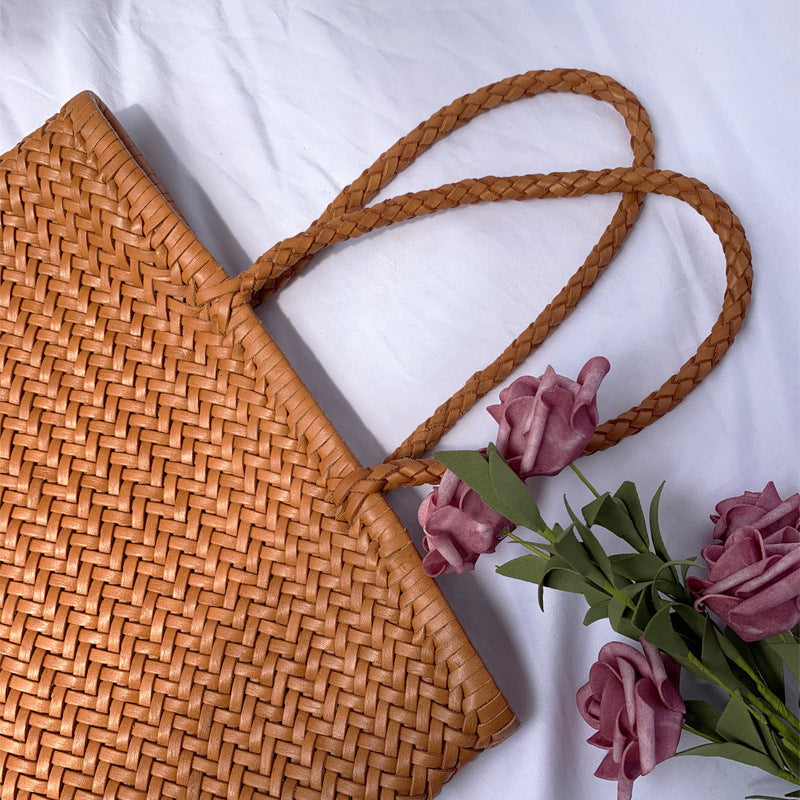 Woven brown bag with pink roses on a white background