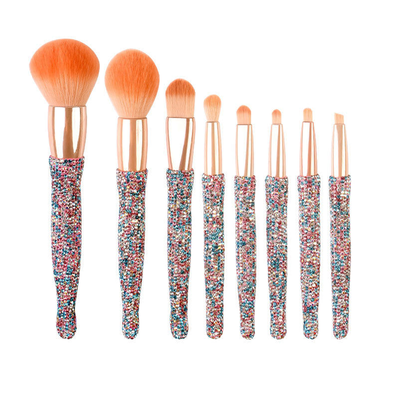 Set of eight makeup brushes with colorful handles on a white background