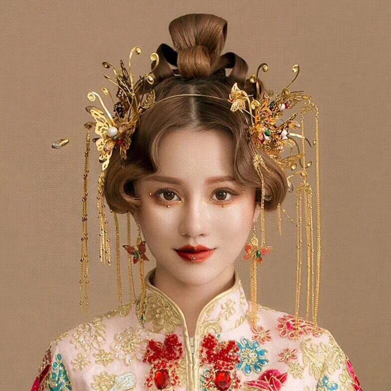 Traditional Chinese hairstyle with decorative headpiece on a plain background