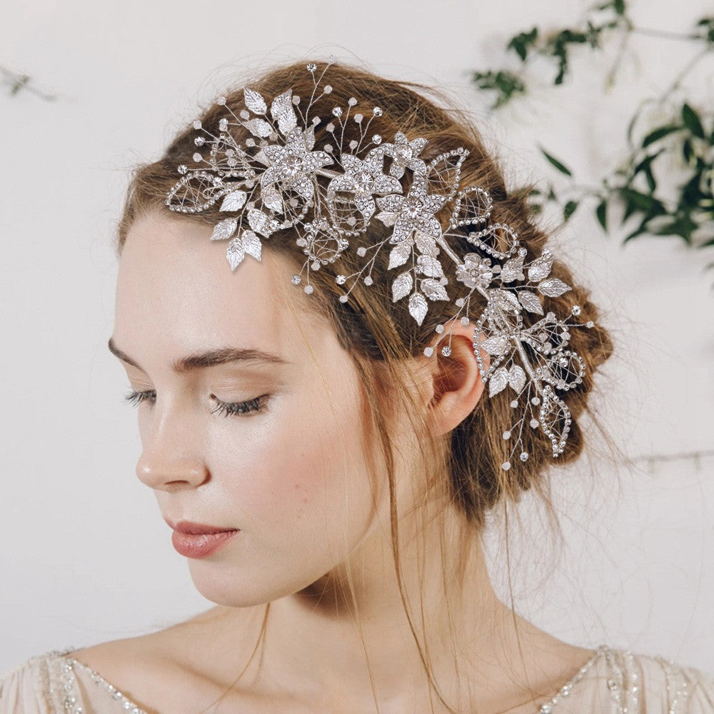 Woman wearing a decorative silver hairpiece with leaves against a white background