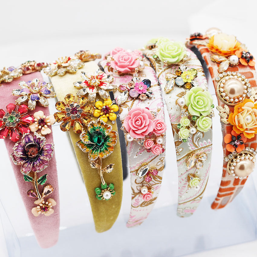 Decorative headbands with floral and gemstone embellishments on a white background