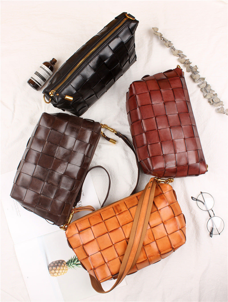 Four woven handbags in black, brown, and orange on a light background.