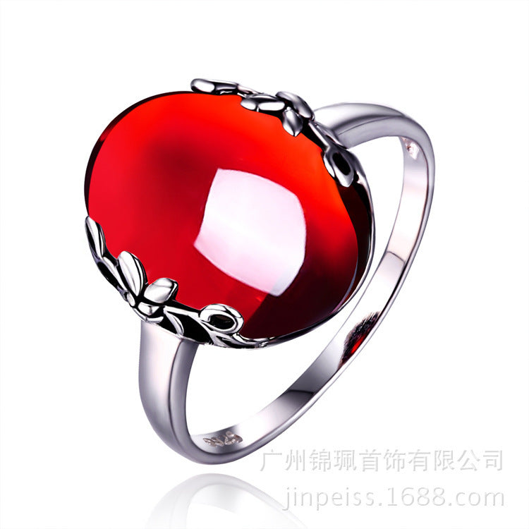 Silver ring with a red gemstone on a white background