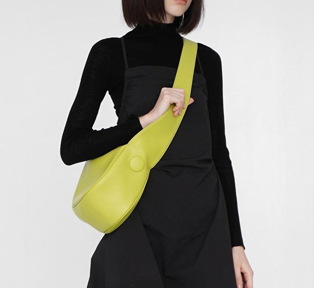 Person wearing a black outfit with a yellow bag on a white background
