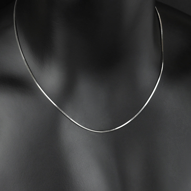 Silver necklace on a black mannequin with a dark background