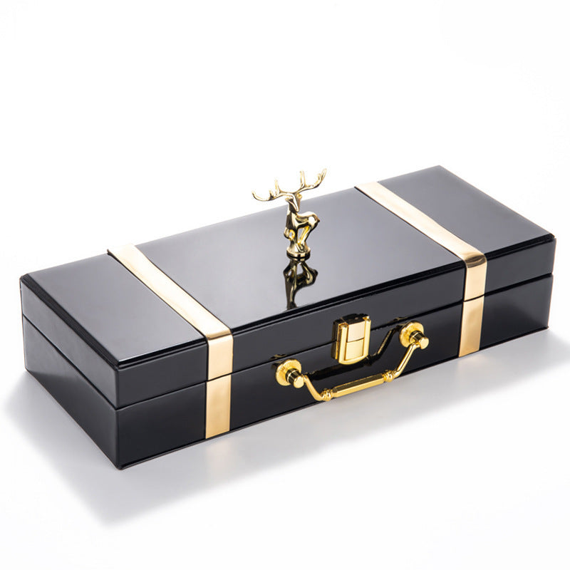 Black jewelry box with gold accents and a deer figurine on a white background