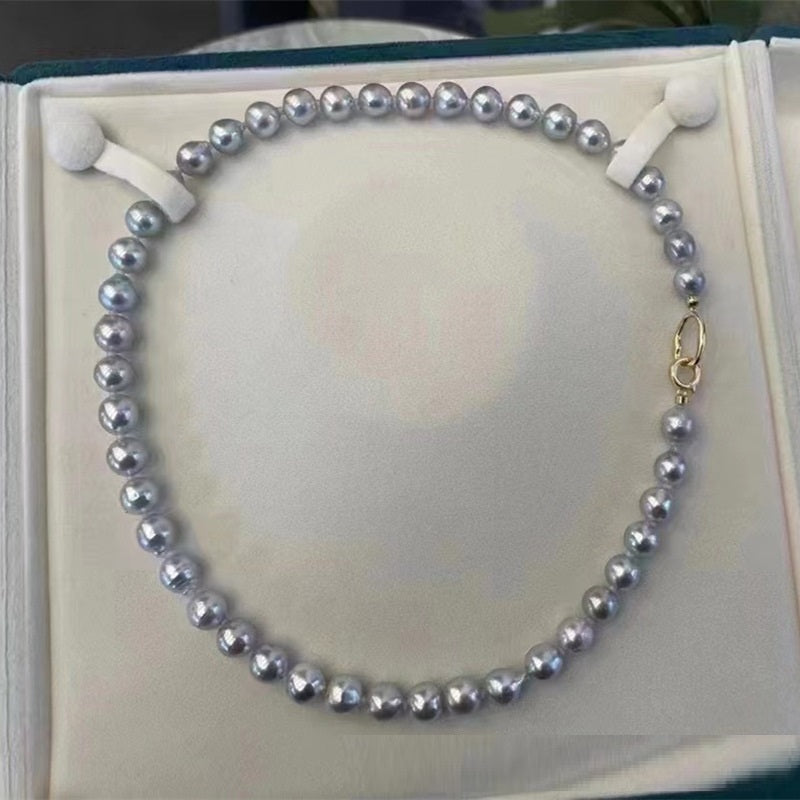 Pearl necklace on a white card with a gold clasp