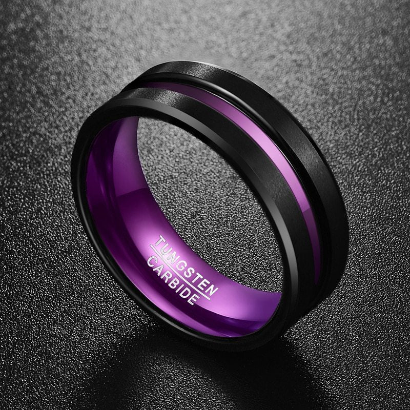 Black and purple ring with 'Tungsten Carbide' engraving on a dark textured background