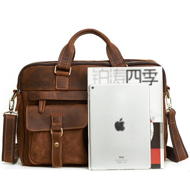 Brown leather briefcase with an Apple product and magazine on a white background