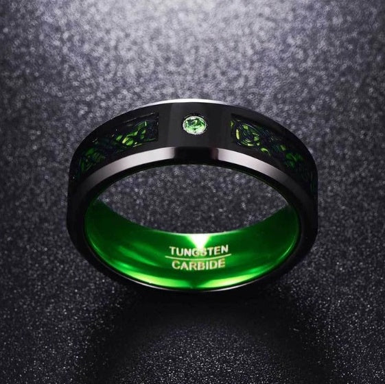 Tungsten carbide ring with green gemstones on a dark textured background