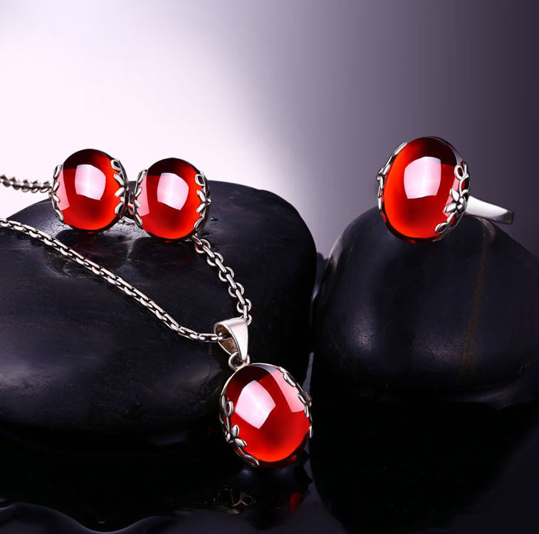 Jewelry set with red gemstones on dark stones
