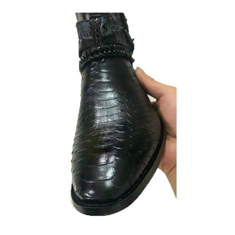 Black leather boot with a textured sole held by a hand on a white background