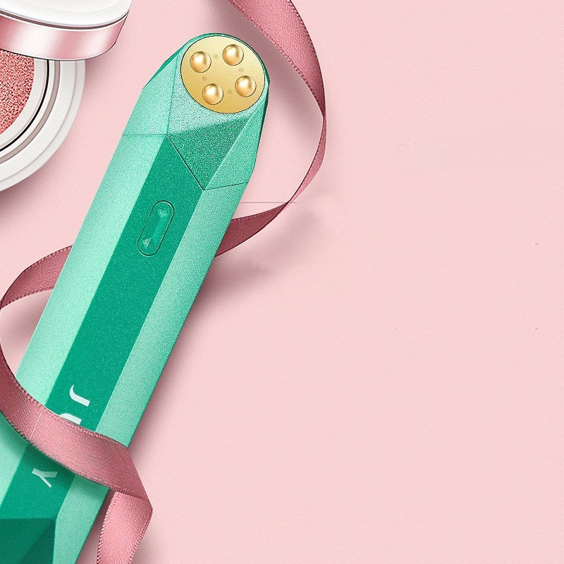 Green electronic device with gold top on a pink background