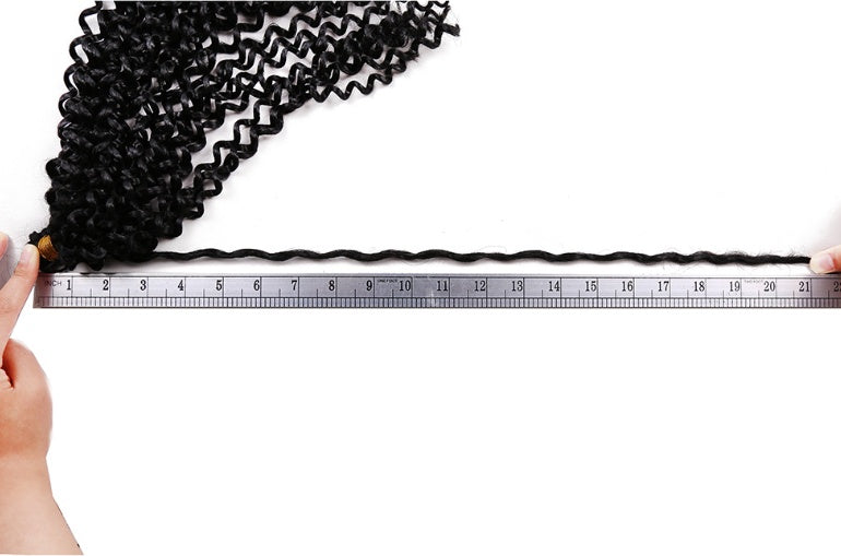 Black hair extensions being measured with a ruler on a white background