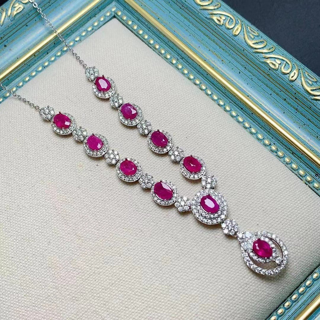 Necklace with pink gemstones and silver accents on a textured surface
