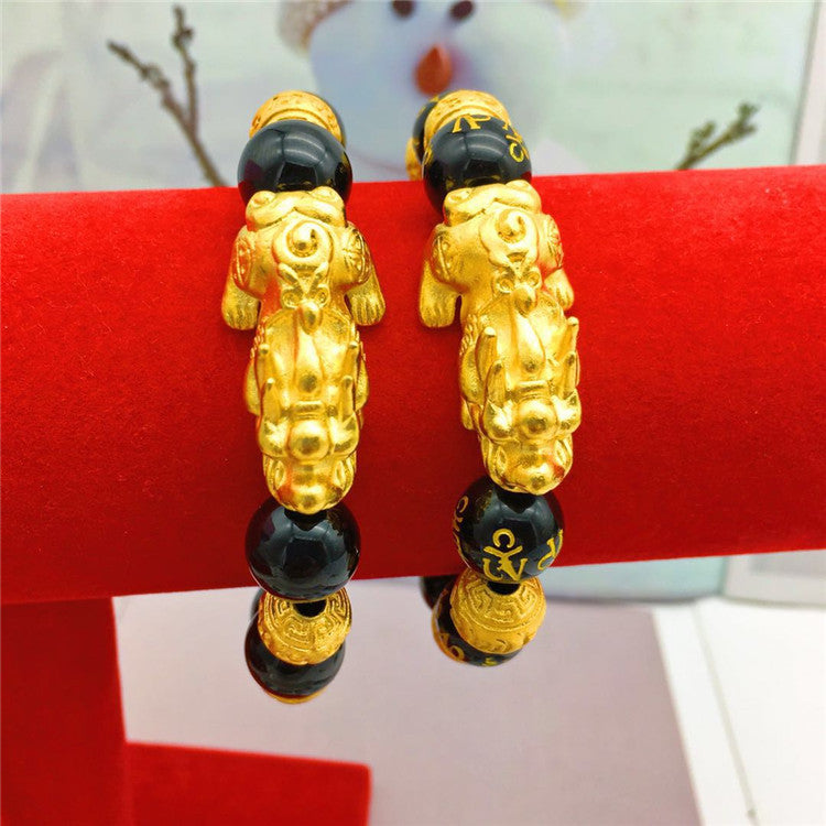 Gold and black earrings on a red stand with a blurred background