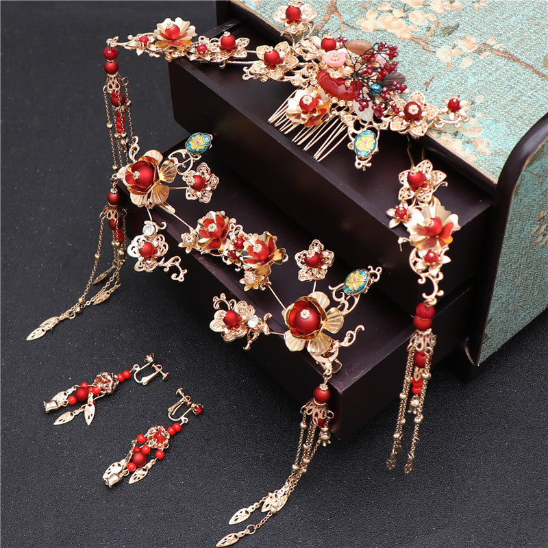 Ornate hair accessories with red beads and gold details on a dark surface.