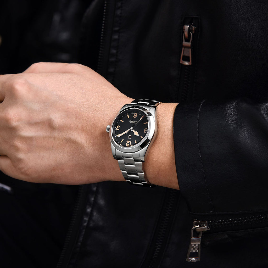 Silver watch on a person's wrist with a black jacket background