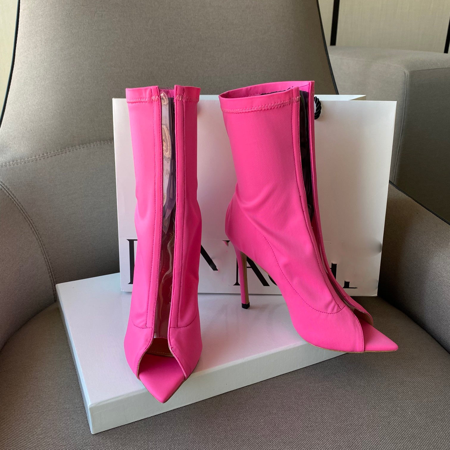 Pink high-heeled boots on a white platform with a blurred background