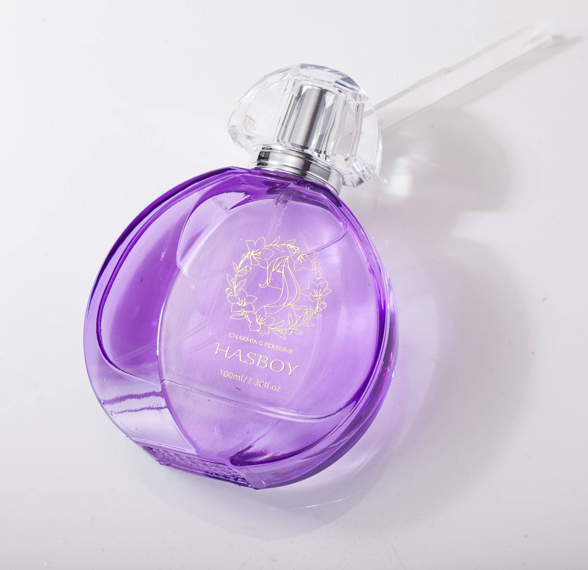 Purple perfume bottle with silver cap on a white background