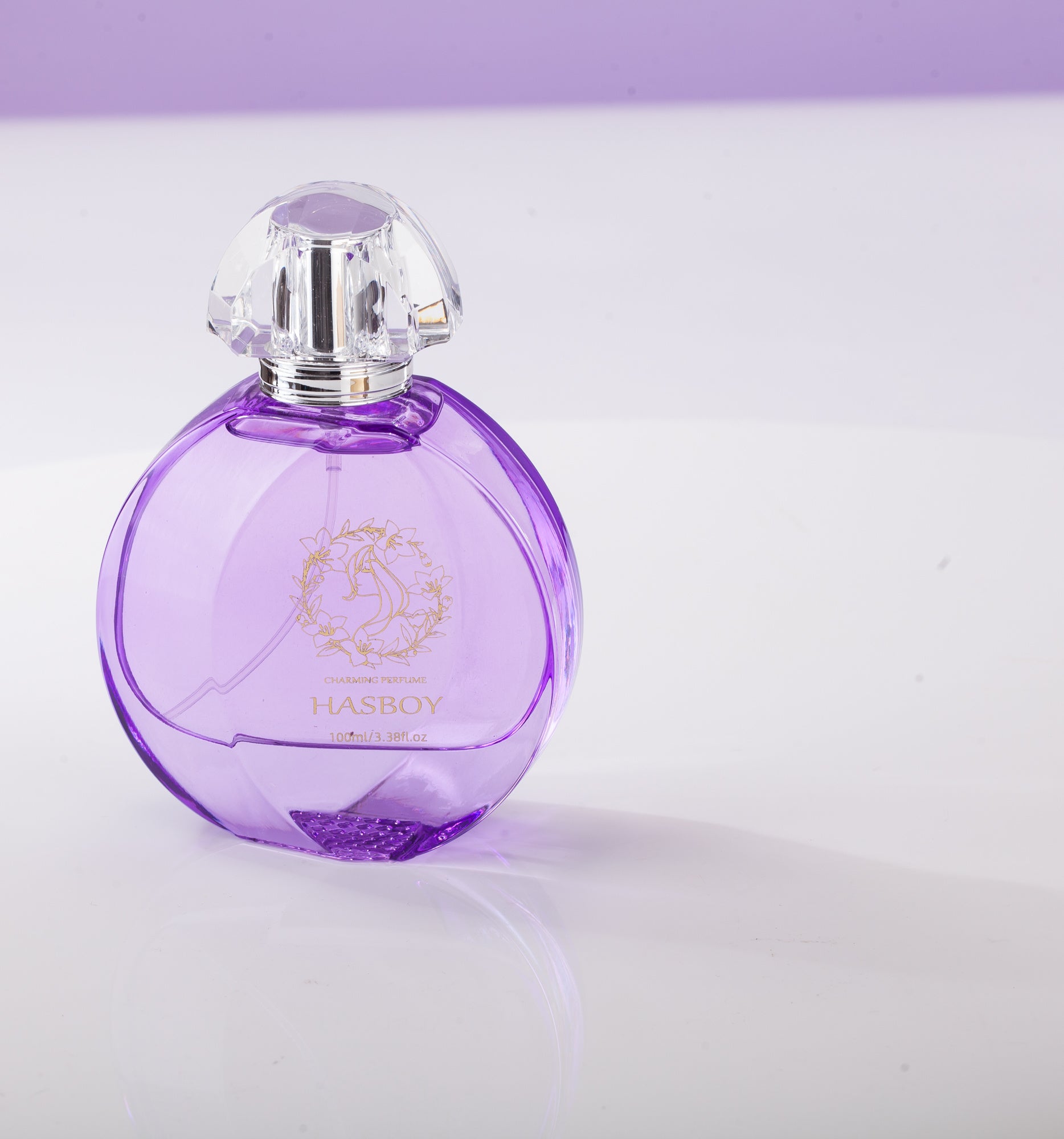 Purple perfume bottle with a clear cap on a light purple background