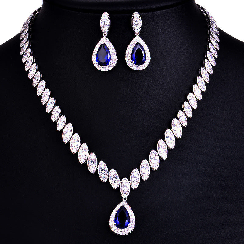 Jewelry set with necklace and earrings featuring blue gemstones on a black background
