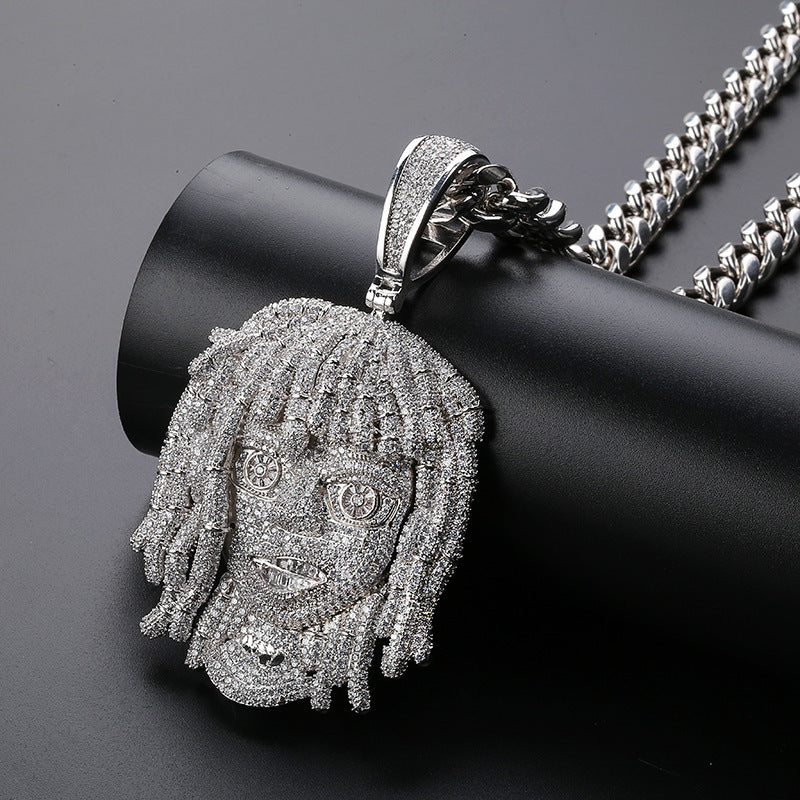 Silver pendant with intricate design on a black surface