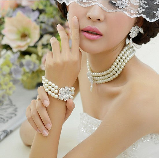 Woman wearing pearl jewelry with a floral background