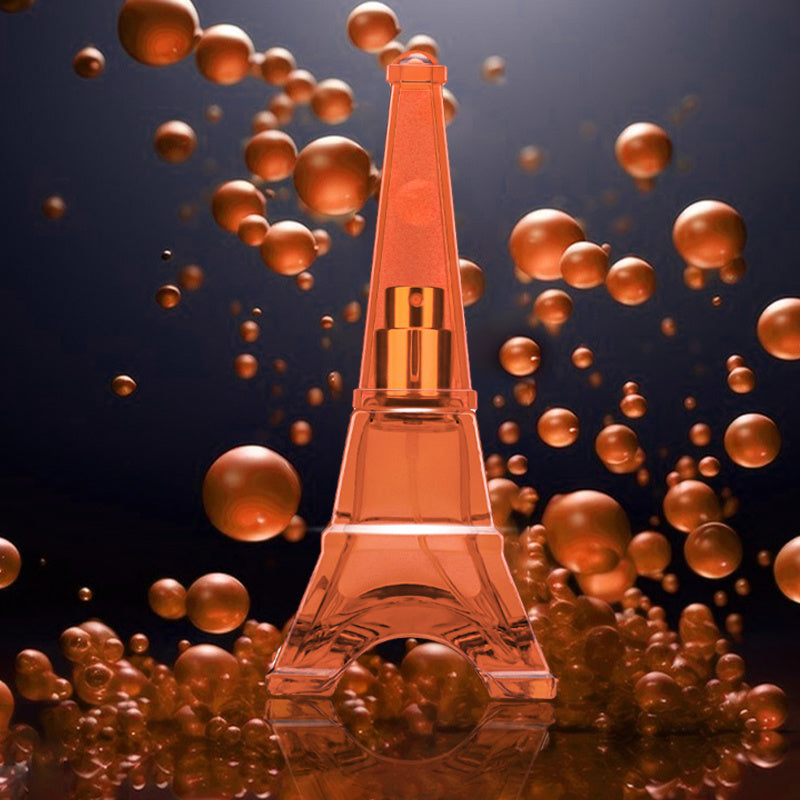 Eiffel Tower-shaped perfume bottle with gold accents surrounded by floating bubbles on a dark background