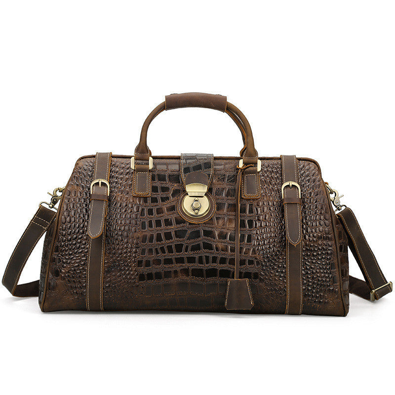 Brown leather handbag with crocodile pattern on a white background