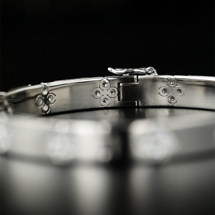 Close-up of a silver bracelet with intricate designs on a black background