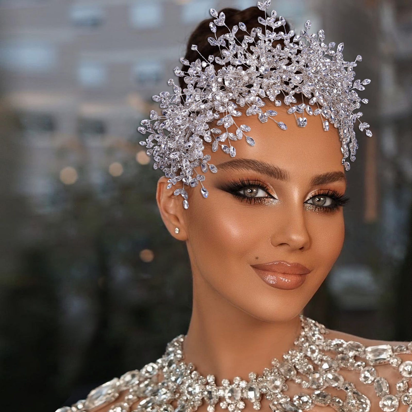 Woman wearing a sparkling silver headpiece and dress with a blurred background