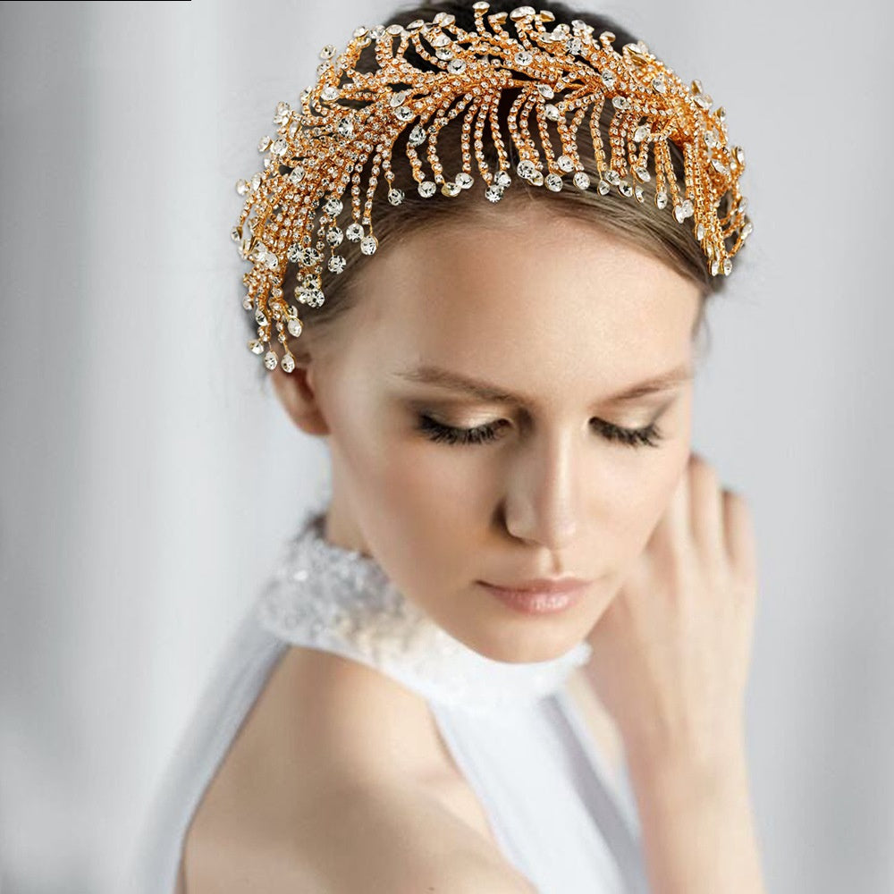 Woman wearing a gold and crystal headpiece against a white background