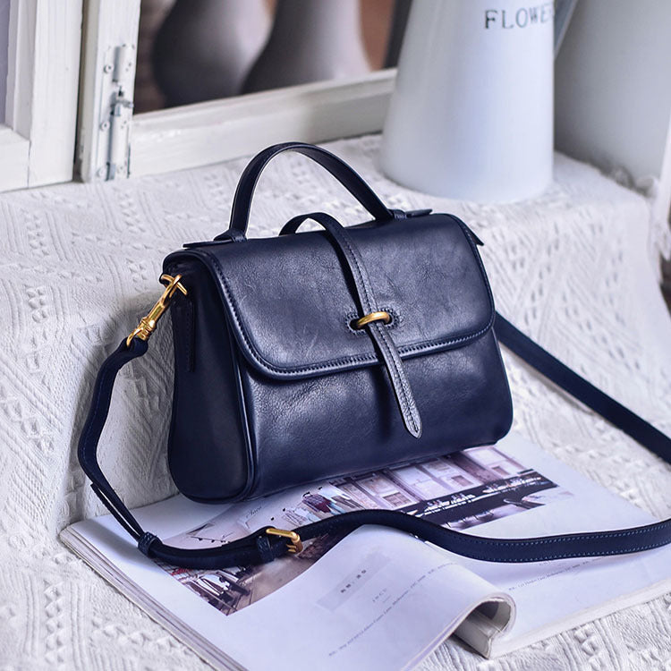 Black handbag with gold accents on a textured surface
