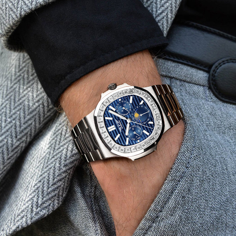 Luxury watch with a blue face on a person's wrist, wearing a gray coat.